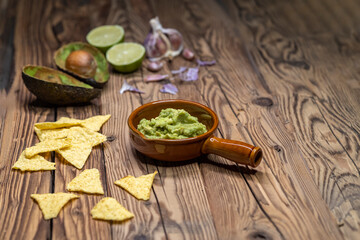 avocado dip flavored with garlic, chili, pepper, and lime juice with corn nachos