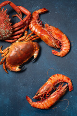 Assortiment de Fruits de mer: araignée de mer, crabe et gambas sauvages sur le fond bleu