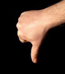Thumb down male hand sign isolated on a black background