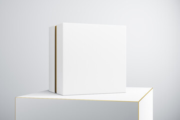 Blank white gift box with golden line on podium.
