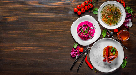 three-course set on a table. Tasty lunch set made of three meals, such as soup, salad and sausage with vegetable