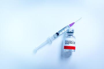 Vaccine bottle and syringe injection COVID-19 infection on blue background. Design Coronavirus Covid-19 vaccination concept.