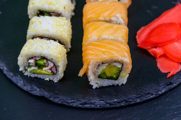 Set of sushi rolls on a black stone slate