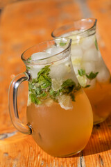 two mugs with mojito on wooden table