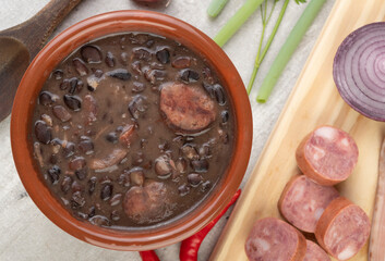 Traditional brazilian feijoada in a bowl with ingredients