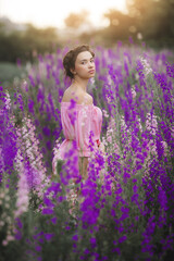 Sexy elegant woman on the meadow of flowers. Beautiful female outdoors. Freedom concept