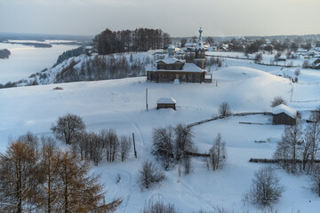 Panoramic view from the old bell tower to Cherdyn (Northern Ural Russia), located on several hills. Historic center with beautiful wooden churches, houses, trees and deep snow on a winter day 