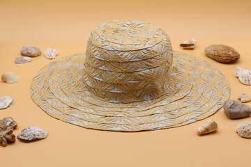 Fototapeta na wymiar female straw hat, stones and shells surrounding. monochrome concept