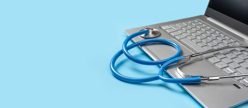 Online doctor consultation, Virtual hospital and online therapy. stethoscope lies on laptop keyboard on blue background. Healthy Hardware. copy space. banner