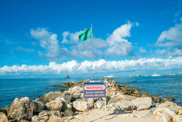 Green flag pole posted to signal the sea water conditions are safe in the caribbean
