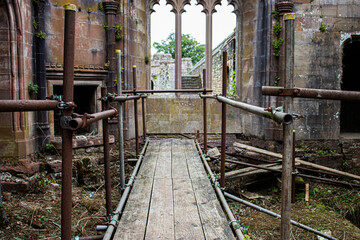 Rusty scaffolding and board walkway in an old church ruins.