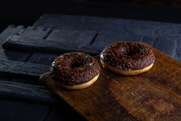 Donuts on a wooden board on a blue concrete background