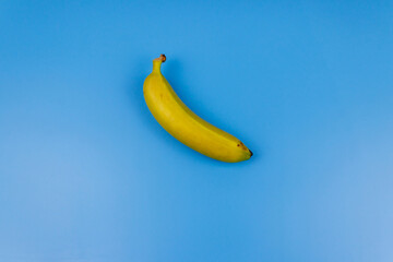 Yellow banana on pastel blue background. Top view, flat lay, minimal design