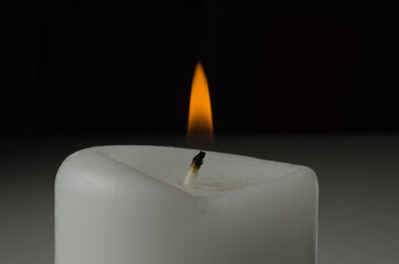 burning candle on black background