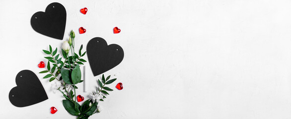 Wide banner with flowers, chalkboard hearts and red decorative hearts on the white table. Copy space. Valentine's Day