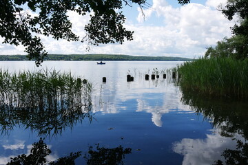 Wolken spiegeln sich im Wasser des Sees - Tollensesee