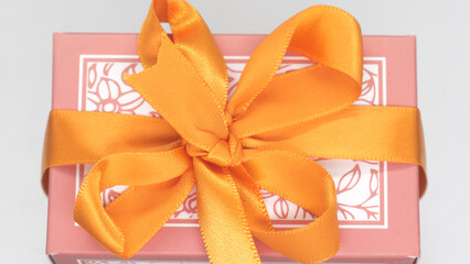 Pink gift box with orange bow for a fun holiday or birthday party