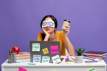 Tired indian woman sitting at desk with sticky notes