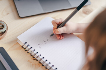 Distance learning online education. Caucasian smile kid boy studying at home with laptop, writing...