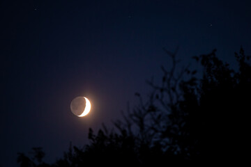 young crescent moon with the dark side in sight 