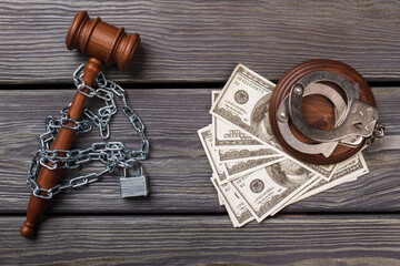 Flat lat arrest for corruption in a court concept. Chained wooden gavel with padlock, bunch of dollars and handcuffs.
