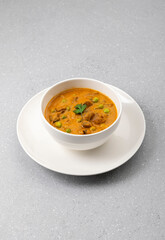 creamy peas and mushroom curry in a white bowl