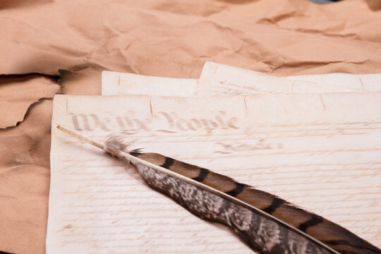 Old historical document with quill. Feater on the pages of ancient script.