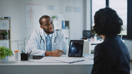 Young Black Medical Doctor Showing Mammography Test Results to a Patient on a Tablet Computer in a...