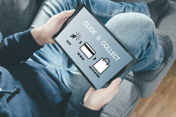 close-up of person on sofa holding tablet computer for online shopping using a click and collect service - obrazy, fototapety, plakaty