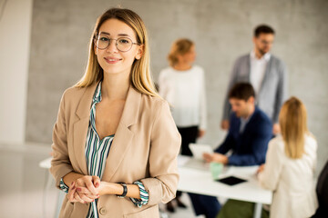 Young business woman standing in the office in front of her team
