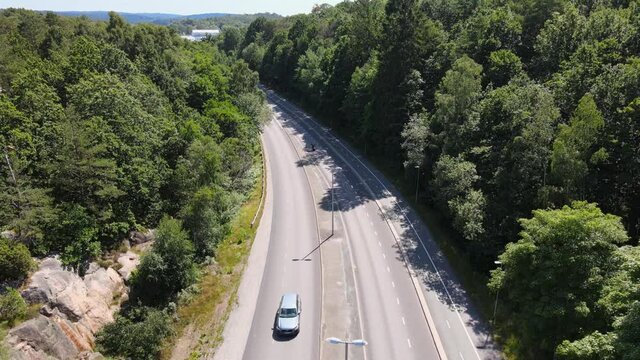 Above aerial view of motorbike accelerating away out of view. Sunny summerday in Gothenburg, Sweden. 4K drone footage.