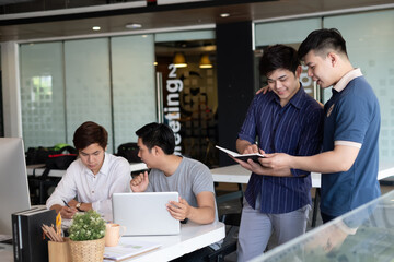 Asian businessman and designers, conference analysis, commenting by laptop and taking notes in the office.