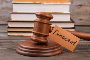 Innocent verdict concept. Wooden court gavel and stack of books.