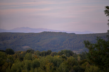 autumn landscape overlooking the horizon where the ridges of the high mountains can be seen. high hills full of dense forests