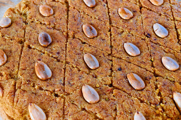 Close-up view of cake with almonds, fenugreek seeds and semolina. Dessert pattern.