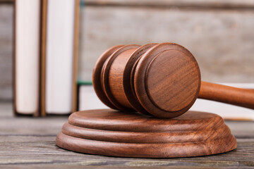 Gavel on sounding block. Law books on the background.