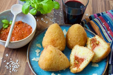 Sizilianische Arancini Reisbällchen mit Glas Rotwein