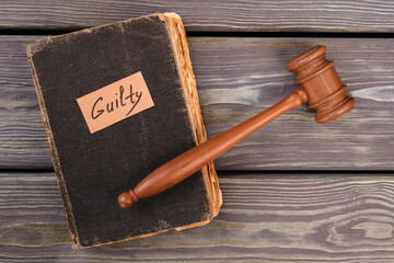 Old book gavel and guilty verdict. Trial justice concept. Top view flat lay.