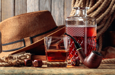 Whiskey, pipe and dice on a old wooden table.