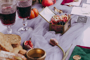 Cute wedding details on the table, glass wedding ring box with glasses of red wine