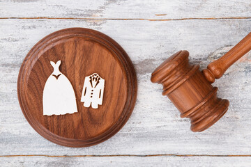 Wedding costumes and wooden gavel. White desk background.
