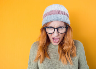 Rage young woman screaming, isolated on yellow background. Frustrated girl