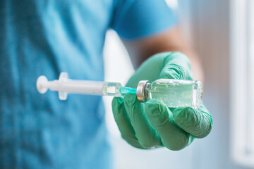 Hands of the doctor filling a syringe with vaccine. medicine, vaccination and drug concept....