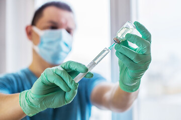 Hands of the doctor filling a syringe with vaccine. medicine, vaccination and drug concept....
