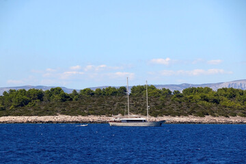 Fototapeta na wymiar Sailing boat near island in Croatia. Beautiful Mediterranean landscape.