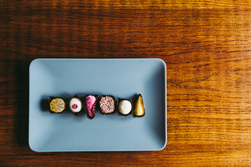 Friandises dans une assiette grise avec des - Assortiment de chocolats pâtes de fruits et fruits...