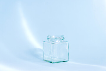 Empty glass bottle on the blue background with light effect