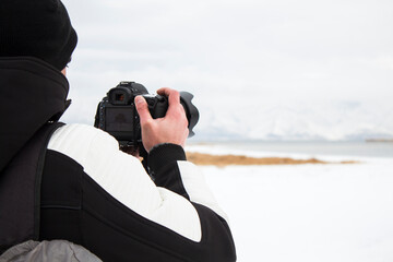 Obraz premium photographer taking pictures of the lake in winter