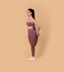 Smiling Young Woman Stretching Leg At Studio