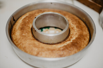 Bizcocho esponjoso casero con forma circular aún en su molde de horno sobre la encimera de la...